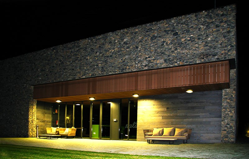 Se muestra la fachada nocturna iluminada